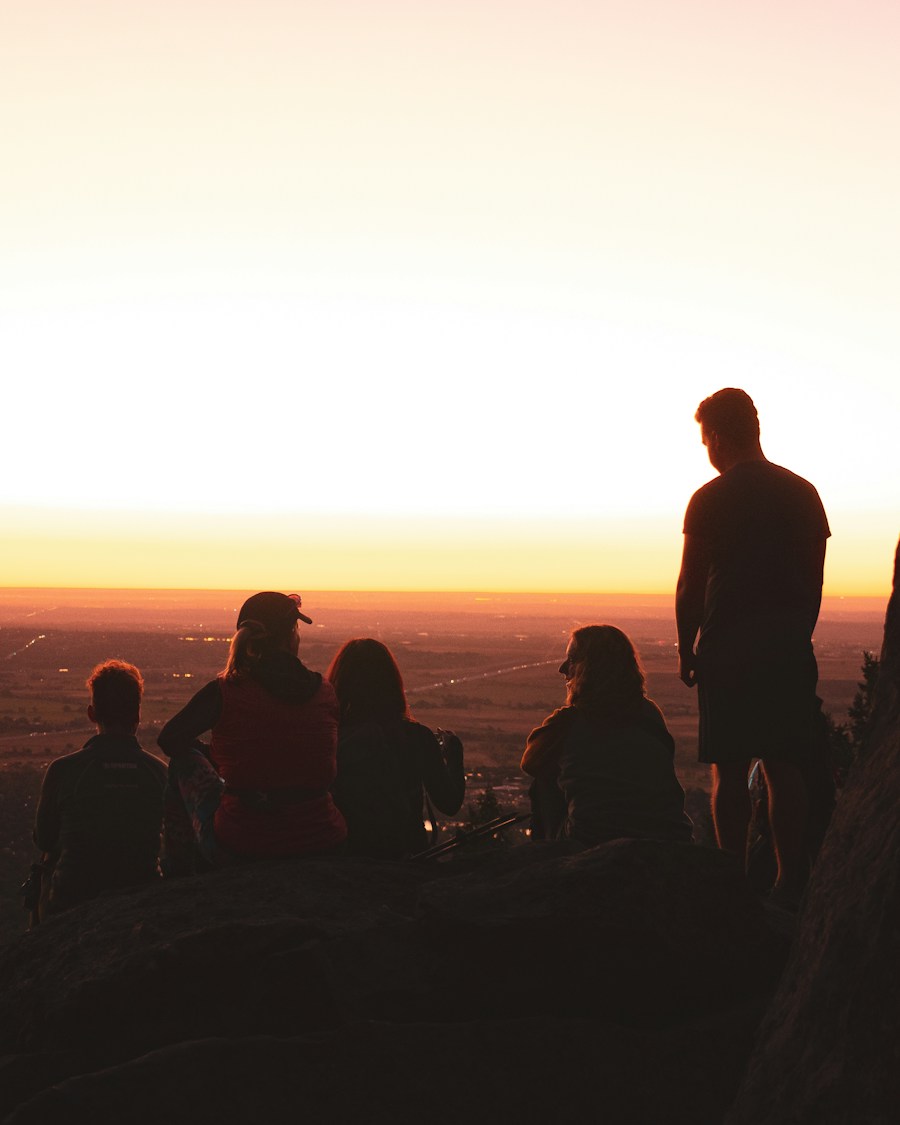 Friends watching sunrise from a rocky cliff overlook